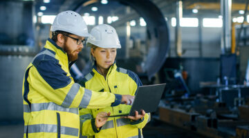 Male and female industrial engineers with hard hats