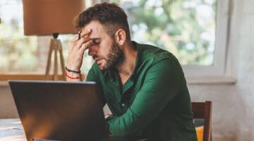 Young man having streesful time during working