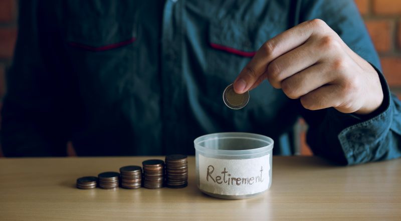 Men are holding coins dropping to the money box with the concept of saving.