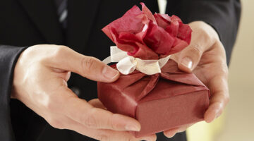 Person holding box with red wrapper