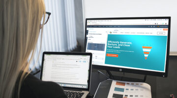Woman working in front of two laptops