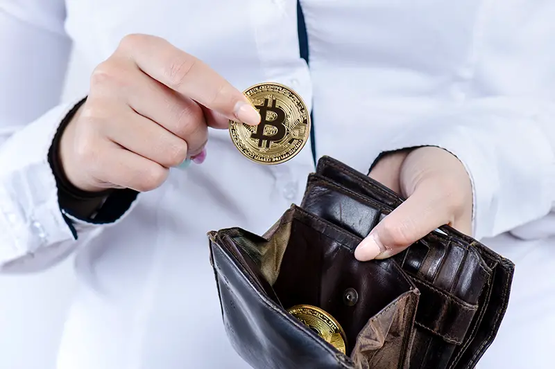 Businesswoman holding wallet with bitcoin