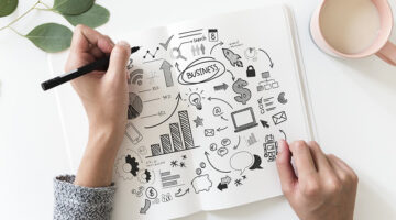 person jotting business ideas down in notebook