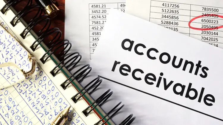 Note pad with figures and paper with account receivable text