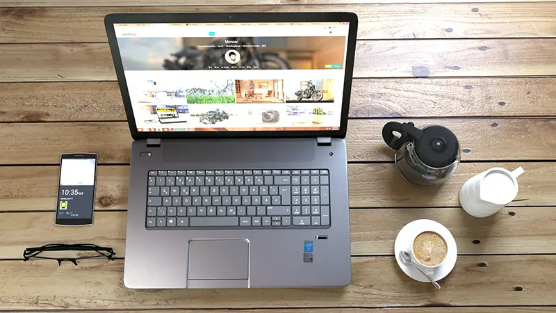 Silver laptop next to coffee cup