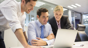 Team members looking at a laptop computer in the workplace