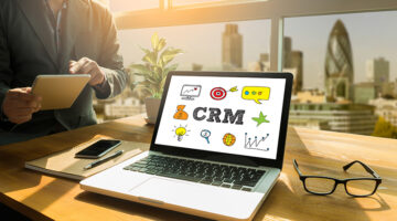 Man holding tablet beside the laptop