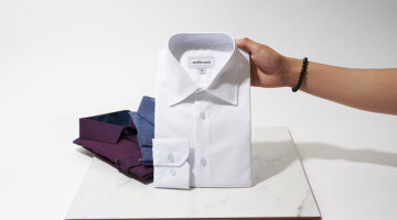 Person holding white polo shirt
