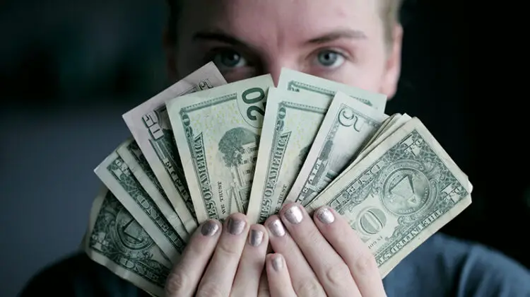 Person holding fan of US dollars