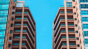 low angle view of two high rise buildings under blue sky