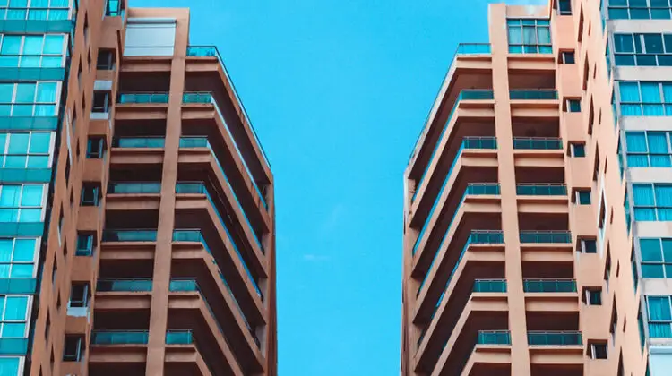 low angle view of two high rise buildings under blue sky