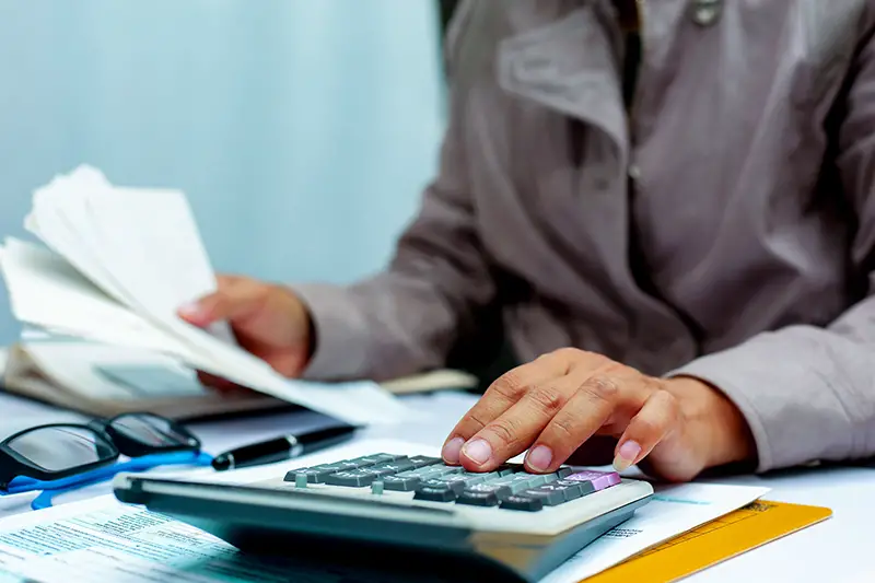 Businesswoman calculating expenses using calculator