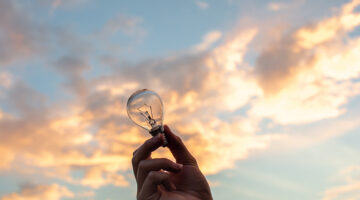 Person holding clear light bulb