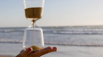 Clear hour glass on person's hand