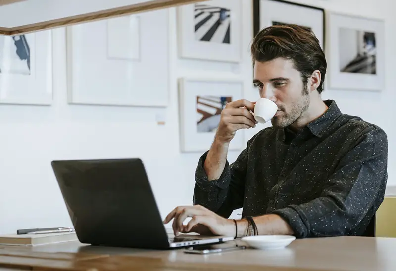 business man sipping a coffee while working