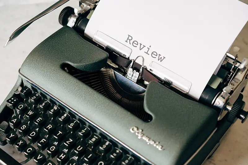 Black and white typewriter with review text