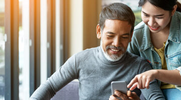 Man with beared and young woman using smartphone