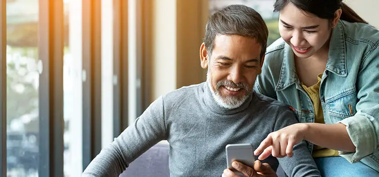 Man with beared and young woman using smartphone