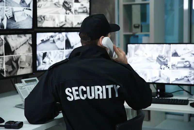 Male security guard talking by telephone in surveillance room