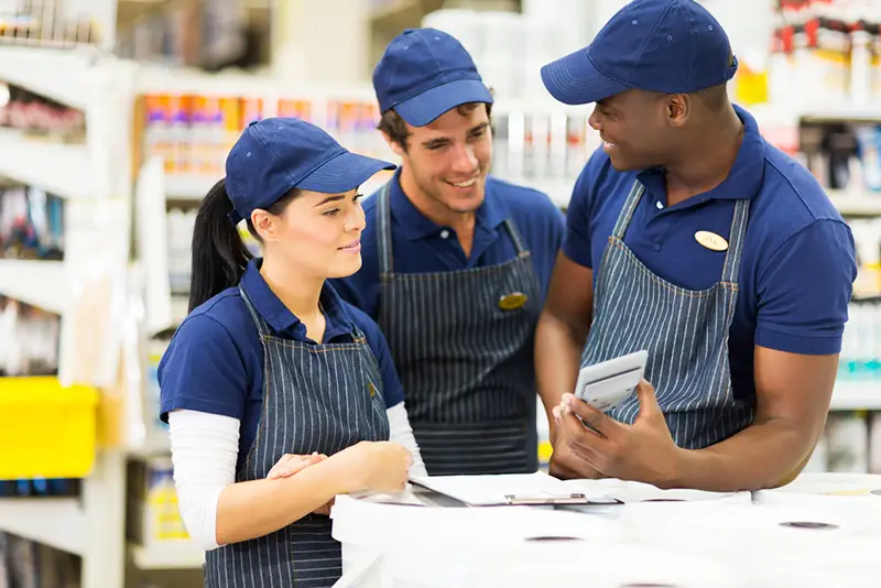 group of hardware store workers in company uniform discussing work