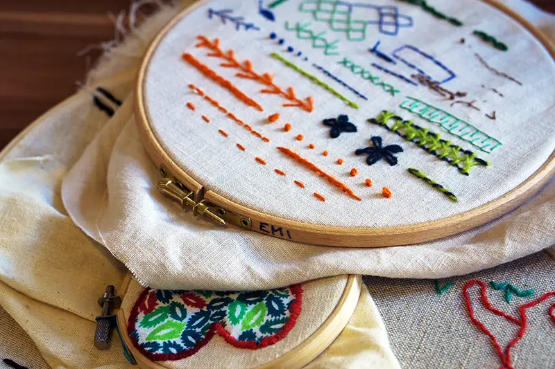 Background with embroidery cloth in embroidery frame, types of embroidery done by hand. Presenting different type of stitches. Embroidery process. Needlework (performed by the author of the images).