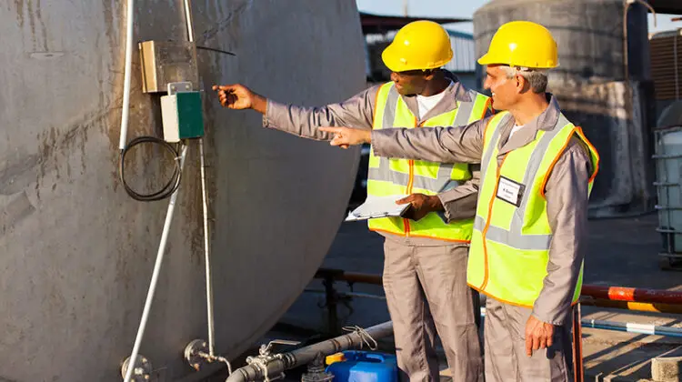 two industrial engineers inspection fuel tank in chemical plant