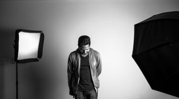 Grayscale photography of man standing in studio