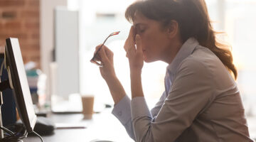 Exhausted female worker sit at office desk