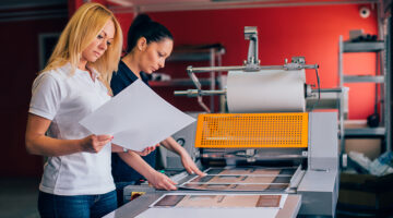 Two young woman working in printing factory.