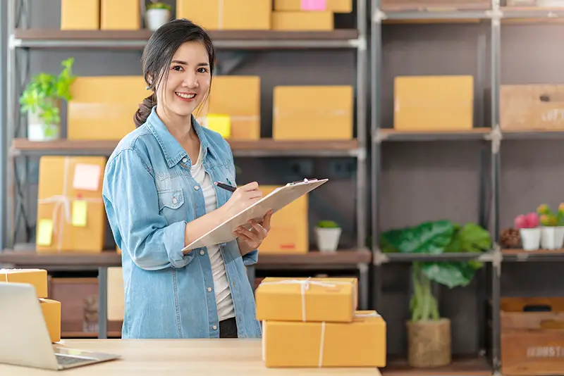 Young asian woman owner startup business work with box at home prepare parcel 