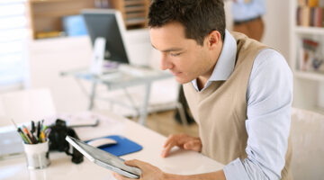 Handsome guy working with tablet in office
