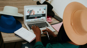Person using macBook air on brown wooden table