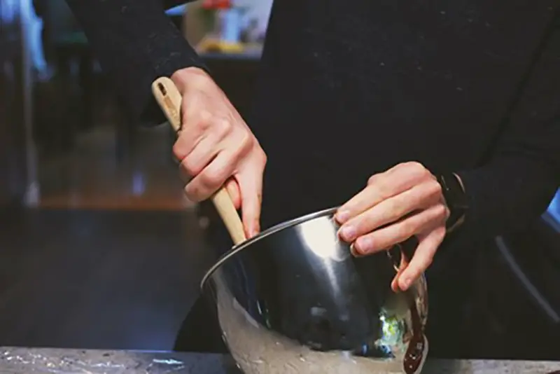 Chef at restaurant mixing food in bowl