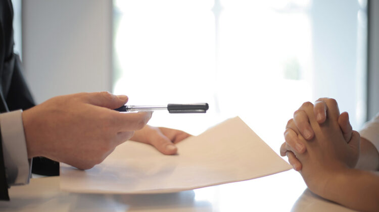 businessman giving contract to woman to sign