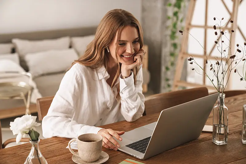 Woman smiling while working on her laptop