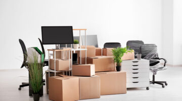 Carton boxes with stuff in empty room. Office move concept. Packing strategy