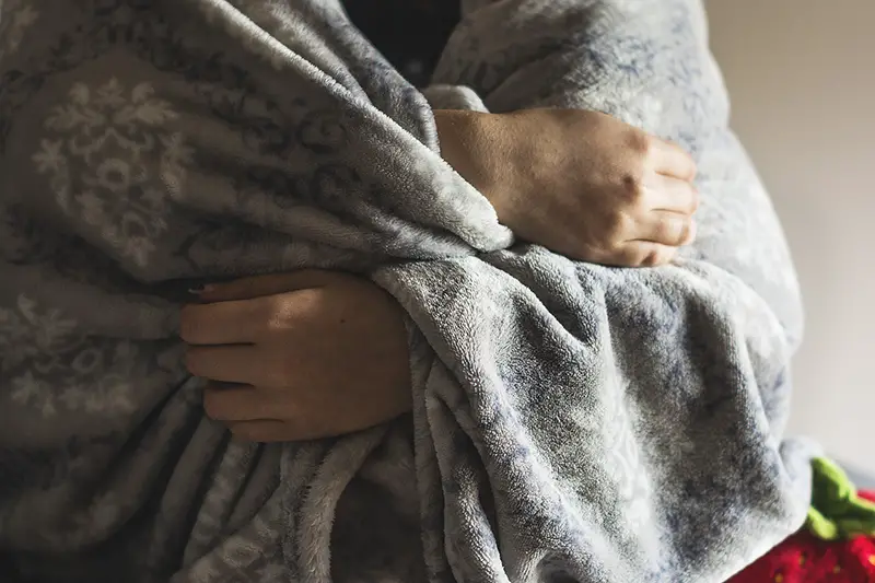 person wrapped in a grey blanket