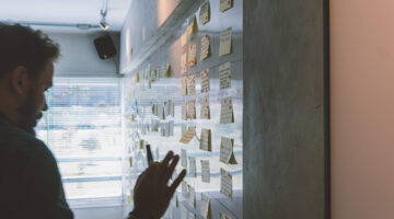 man putting sticky notes on a wall