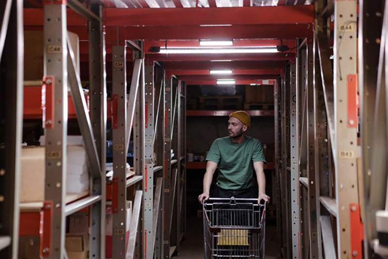 Man in a warehouse pushing a cart