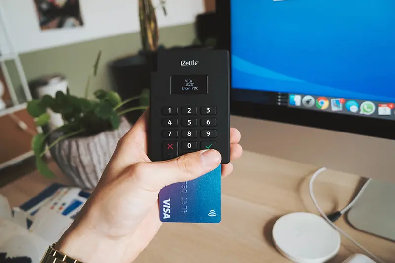 Black sony remote control on persons hand with visa card