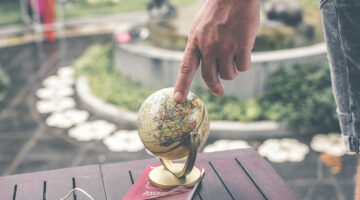 Person holding terrestrial globe scale