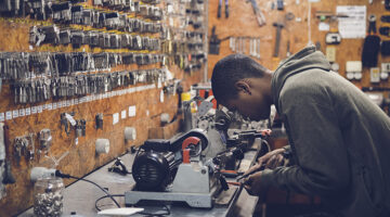 Young man working at work bench in key cutting shop