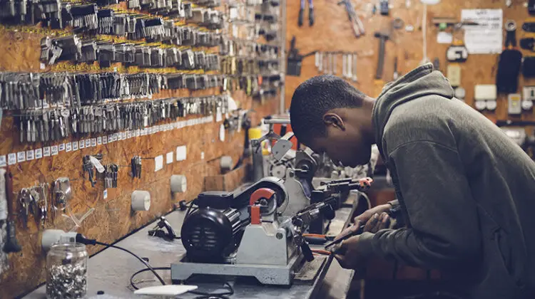 Young man working at work bench in key cutting shop