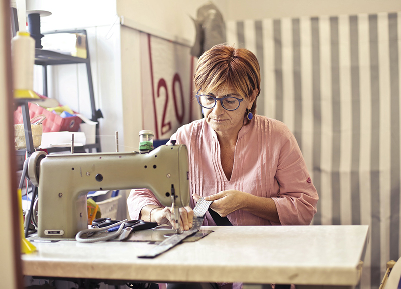 Female working on sewing machine making hand crafts