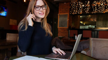 Successful business woman on the phone and working on laptop