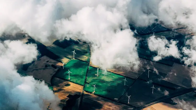 aerial view of windfarm through the clouds - green energy