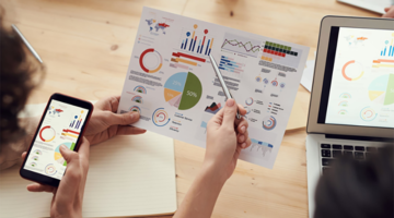 employees looking at business charts on a sheet of paper