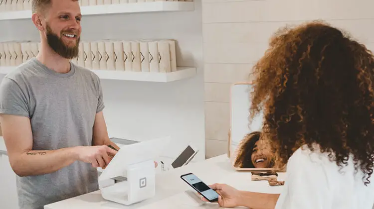 Man in grey shirt smiling to a woman on the counter