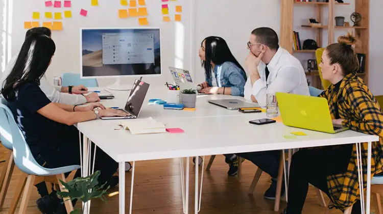 Five person watching turned on screen near white table