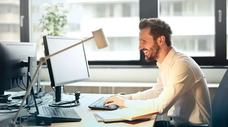 Smiling man working in front of his desk